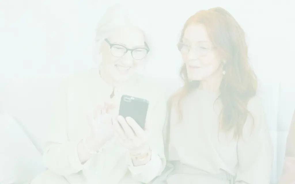 Dwie kobiety patrza w telefon