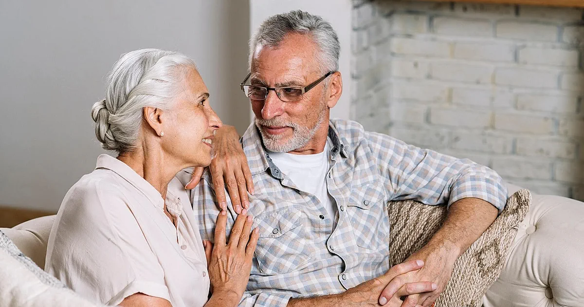 Starsze malzenstwo siedzi na kanapie